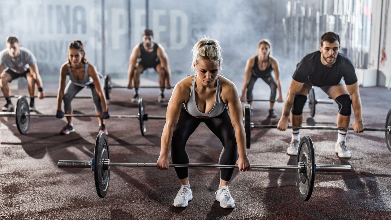 A diverse group of people performing strength training exercises in a gym, representing the inclusivity and benefits of strength training for overall wellness.