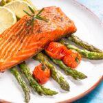 A beautifully plated serving of the garlic butter salmon and asparagus, garnished with lemon slices and fresh herbs. This image should showcase the vibrant colors and presentation of the meal.