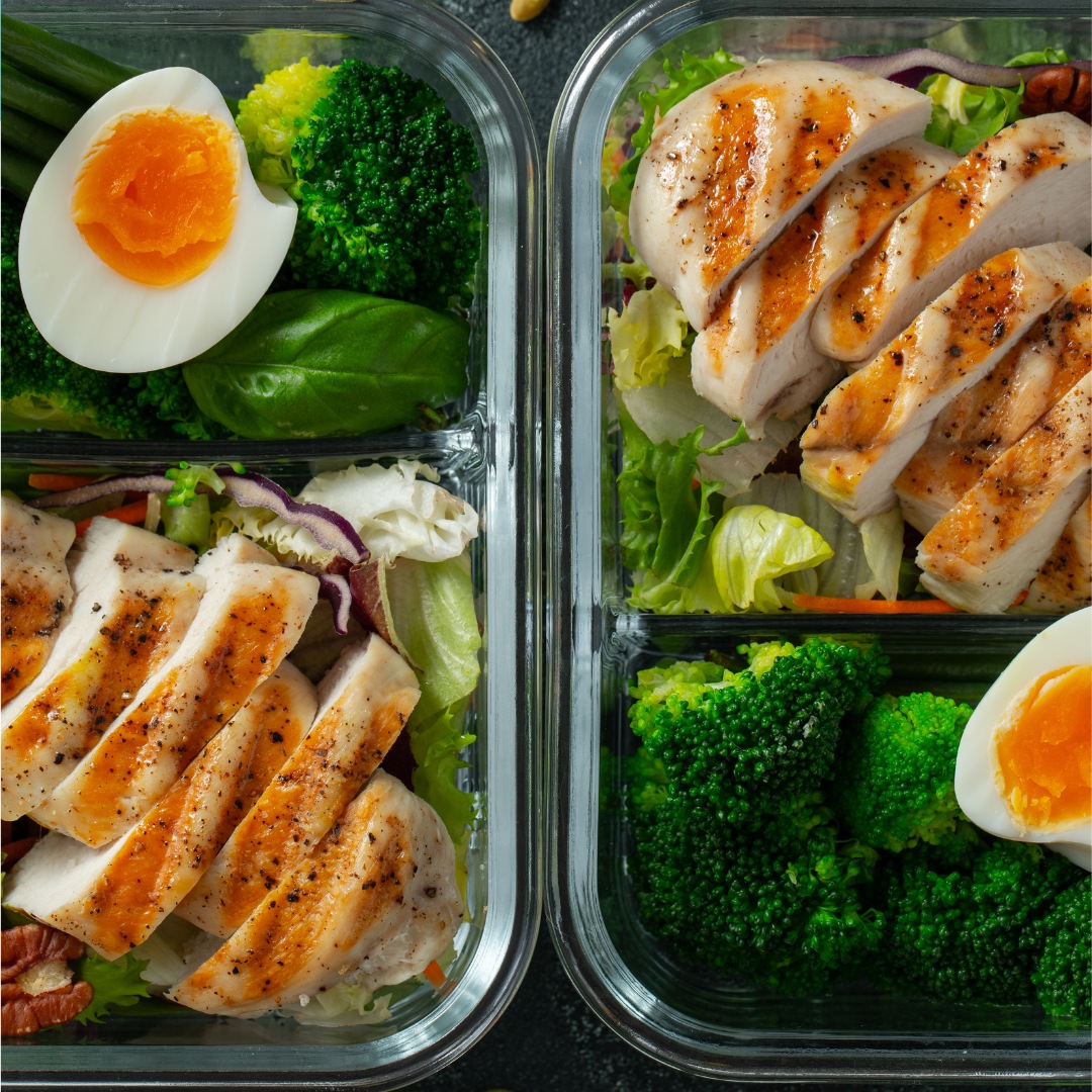 A meal prep layout featuring prepped keto-friendly foods, including grilled chicken, broccoli, eggs, and avocado, ready for a week of ketogenic meals.