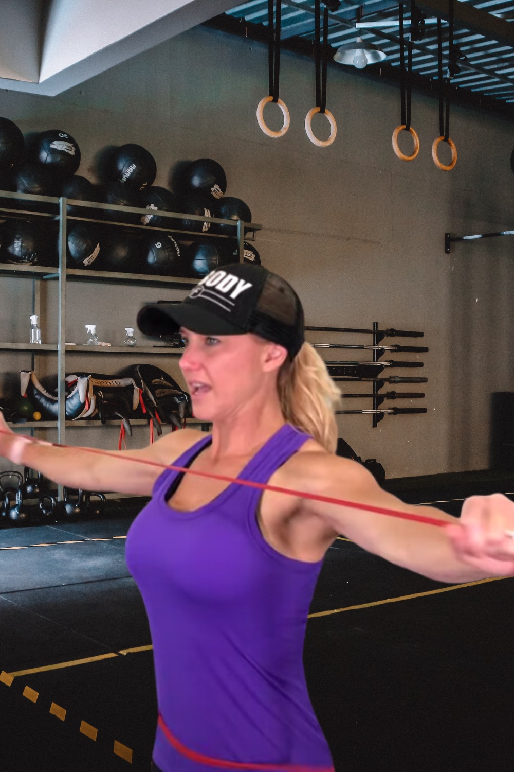 "Woman using a resistance band to perform pull-apart exercise to tone shoulders and upper back."