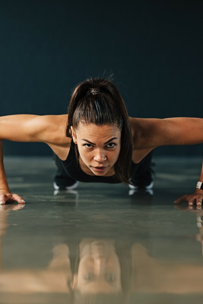 "Woman transitioning from plank position to push-up, engaging core and toning arms."