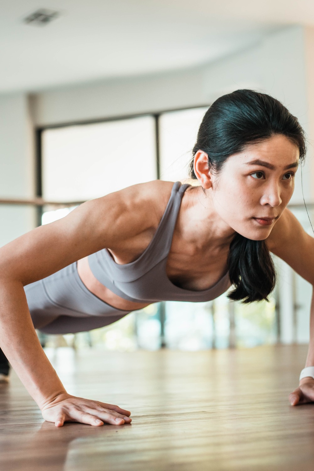 "Woman performing push-ups on the floor to strengthen and tone arms, chest, and shoulders."