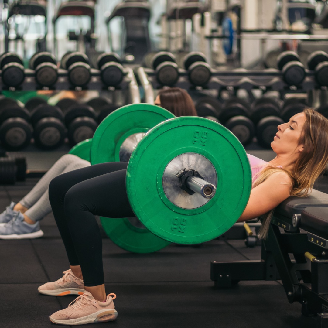 Female athlete demonstrating perfect hip thrust form for glute development