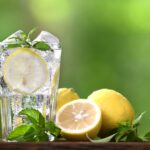 A refreshing glass of water with lemon on a table, symbolizing hydration.