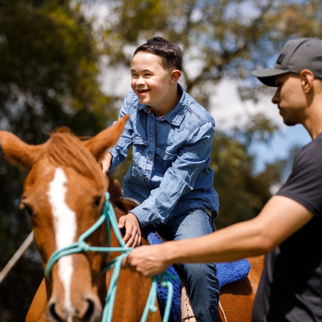 Child with autism interacting with a horse during an equine therapy session