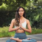 Person meditating in nature, symbolizing stress management and mental clarity.