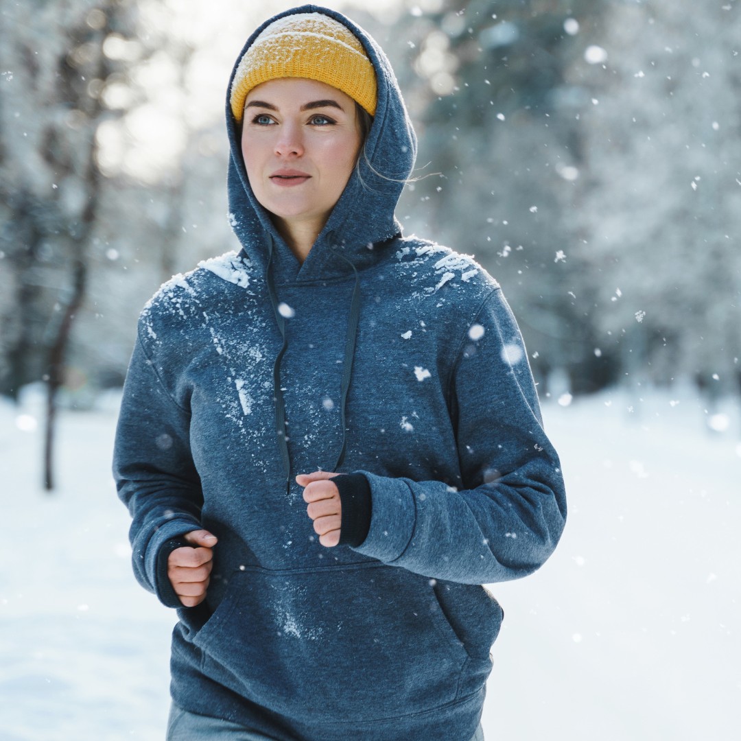 Motivated individuals jogging through a snowy park to keep fitness motivation high during winter.