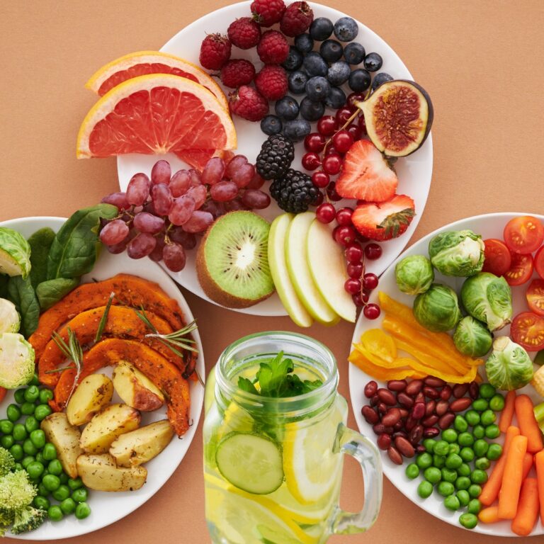 A vibrant plate of fruits and vegetables with a glass of water, symbolizing healthy nutrition for immunity.