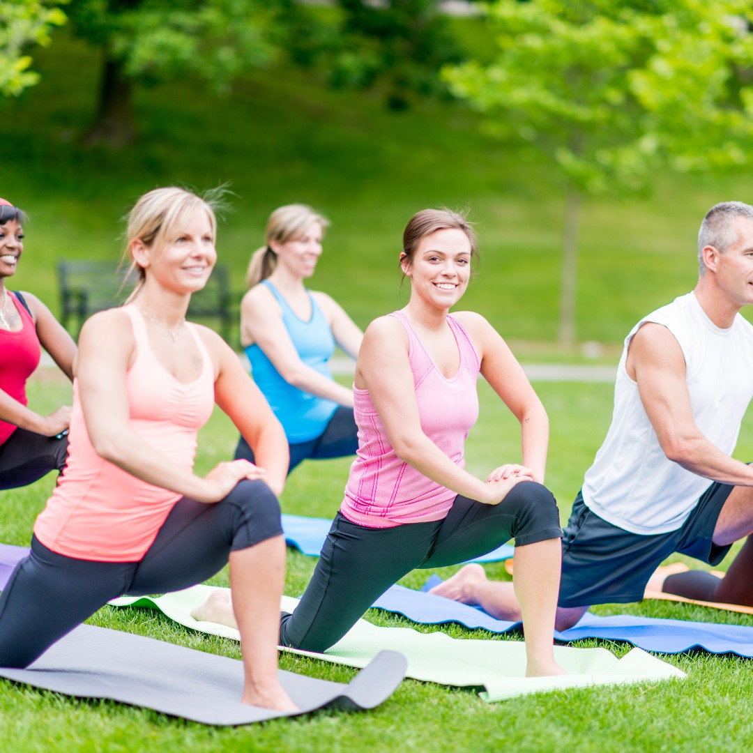 Diverse group of individuals Diverse group of individuals participating in cardio, strength training, and yoga in a park