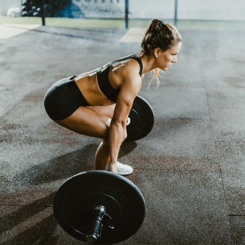 Athlete demonstrating Romanian deadlift with dumbbells.