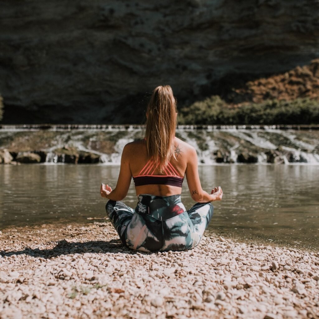 Person practicing mindfulness in nature, focusing on deep breathing.