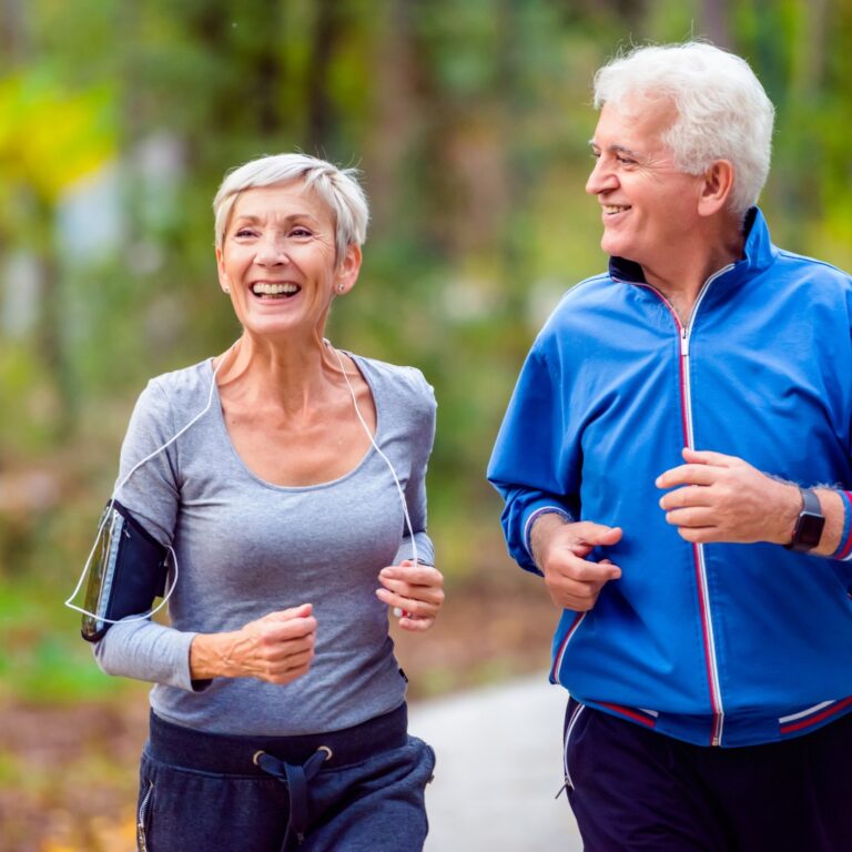 Elderly couple walking outdoors, promoting longevity and active living.