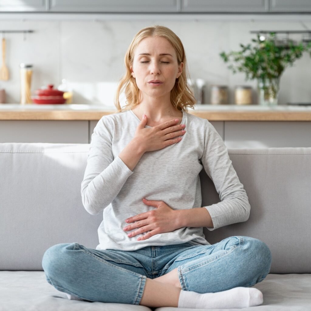A woman practicing deep breathing outdoors for relaxation and mental clarity.