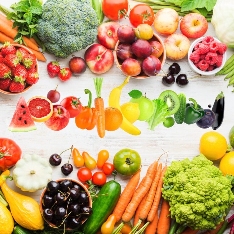 Assorted colorful fruits and vegetables on a wooden table.