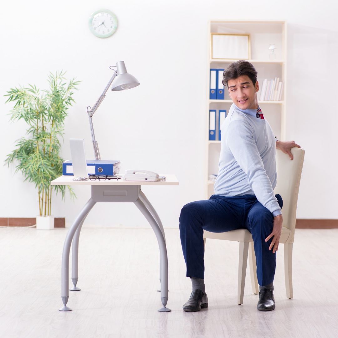 Office worker stretching at their desk to stay active.