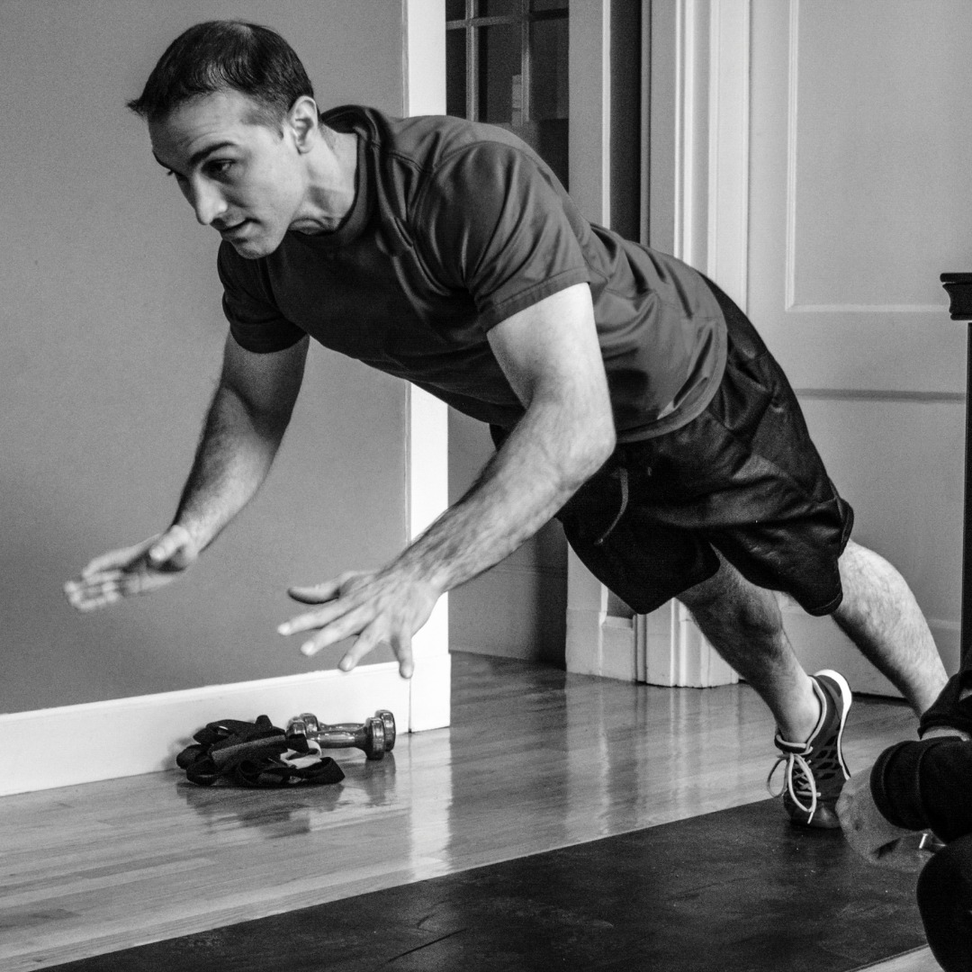 Individual performing plyometric push-ups, demonstrating upper body explosive strength. High-quality photo capturing the explosive movement of plyometric push-ups.